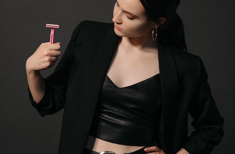 Woman in Black Blazer and Black Pants Holding a Pink Razor